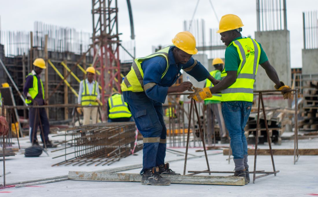 Representative site work showing a crew in safety gear checking reinforcing steel