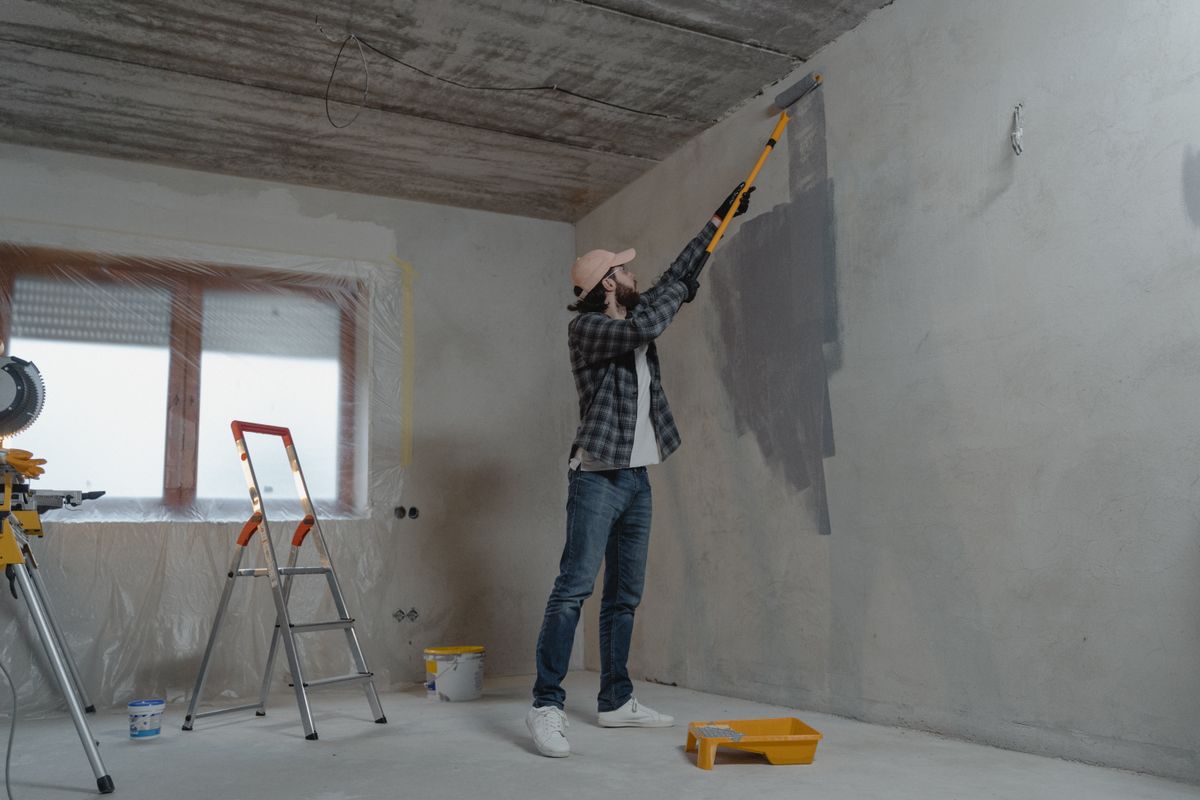 Worker refreshing an interior wall with a paint roller
