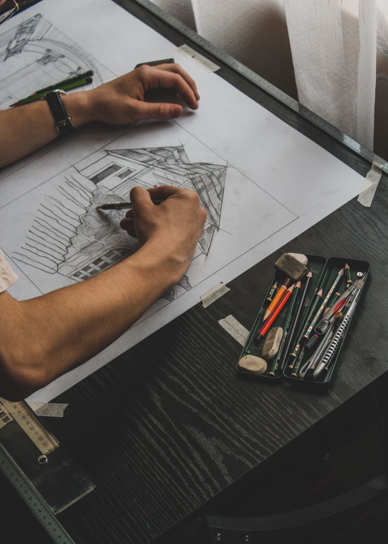 Architect sketching a building with drafting tools